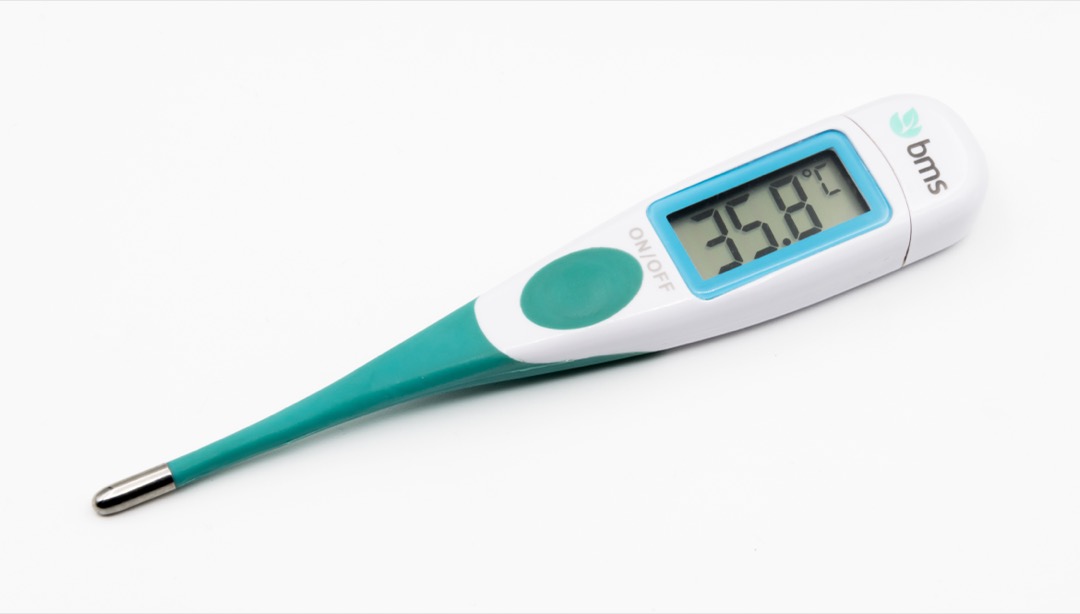 Electronic clinical thermometer with a digital display used for taking a basal body temperature reading before rising