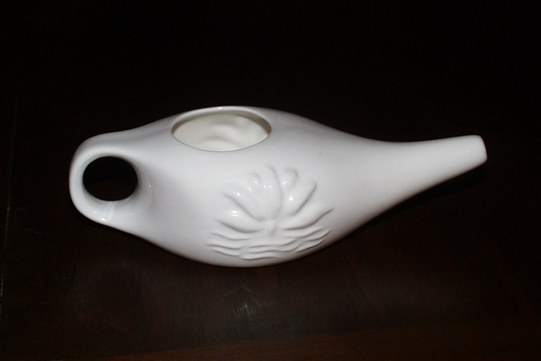 A white porcelain neti pot with a long spout, the classic gravity-fed design used for saline nasal irrigation