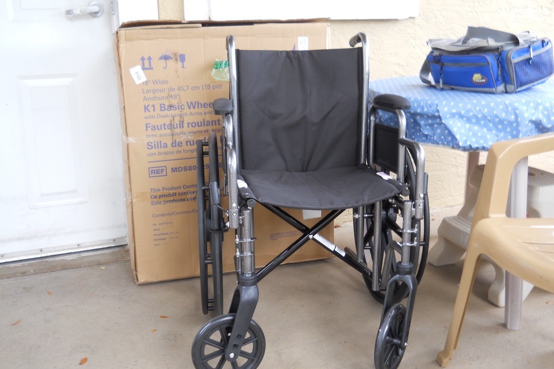 A gray Medline manual self-propelled wheelchair with large rear wheels, handrims, padded armrests, and swing-away footrests photographed against a plain background